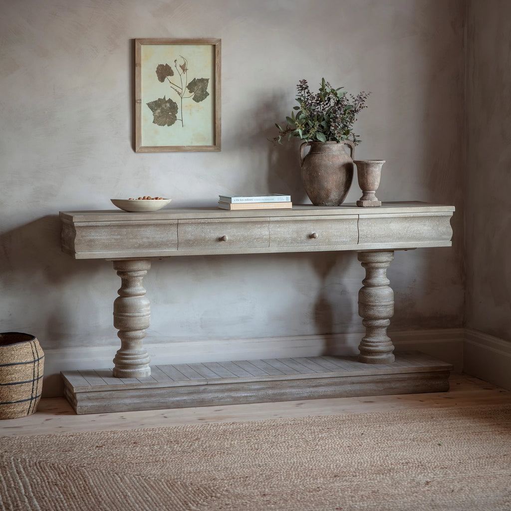 Wooden console table with decorative items against a neutral wall.