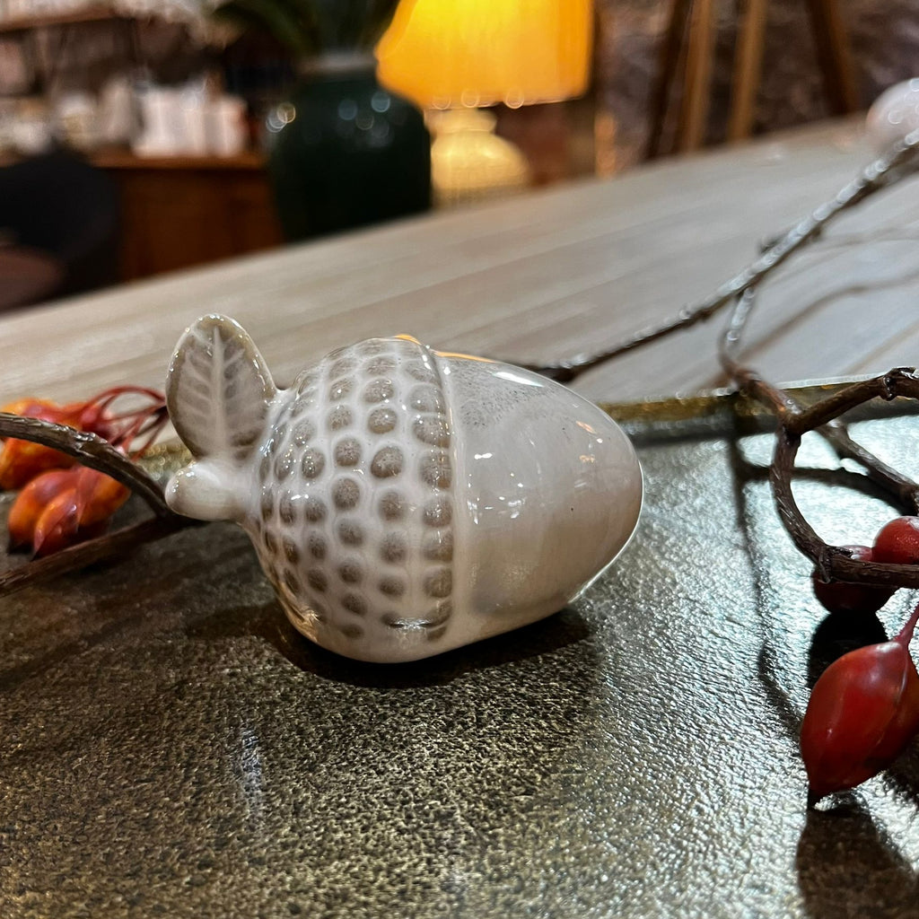 Decorative acorn ornament on a textured surface with blurred background
