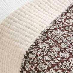 Close-up of a textured fabric with a floral pattern on a neutral background
