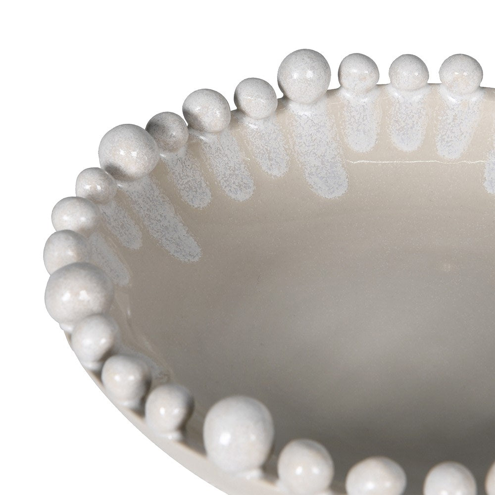 Close-up of a decorative bowl with bead-like embellishments on a white background