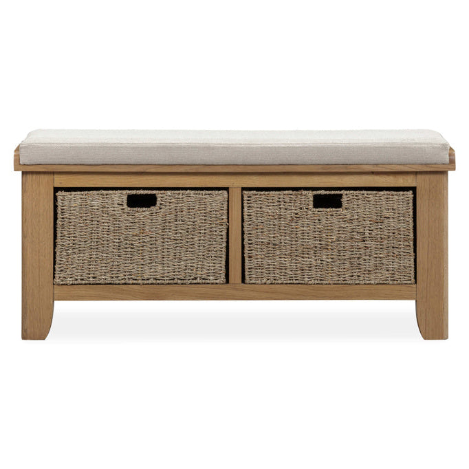 Wooden storage bench with two wicker baskets and a cushion on a white background