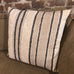 Striped pillow with black lines on a neutral background