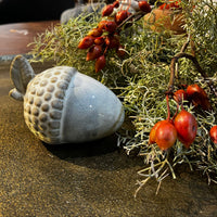 Decorative acorn and berries on a textured surface
