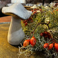 Mushroom-shaped ceramic object on a table with decorative elements