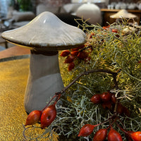 Decorative mushroom with red berries on a table in a room setting