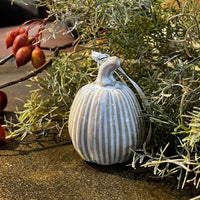 Decorative ornament with ribbed texture on a gold surface with greenery