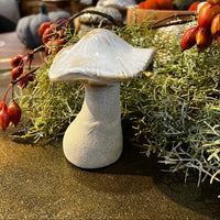Decorative mushroom with berries and greenery on a table