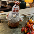 Decorative gnome with a knitted hat on a table with autumn decorations