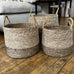 Three woven baskets on a wooden floor with a neutral background