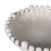 Close-up of a decorative bowl with bead-like embellishments on a white background
