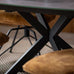Close-up of a table with a metal frame and brown cushioned chairs in a blurred indoor setting.
