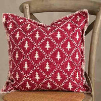 Decorative pillow with red and white pattern on a wooden chair against a neutral background