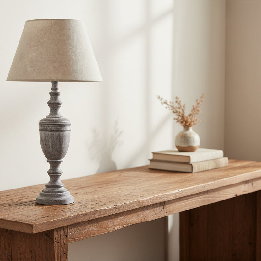 Table lamp with a textured gray base and beige lampshade on a white background