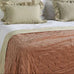 Bed with beige bedding and pillows in a bedroom setting