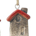 Two ceramic house-shaped ornaments with red roofs on a white background