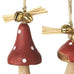 Three wooden mushroom ornaments with red caps and white spots on a white background